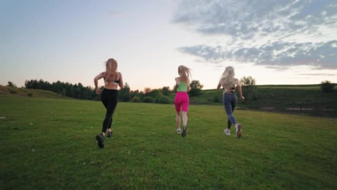 活跃而精力充沛的漂亮女人在大自然中一起跑步，后视，锻炼运动服