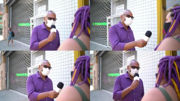 戴着口罩的电视记者在街上采访一名妇女