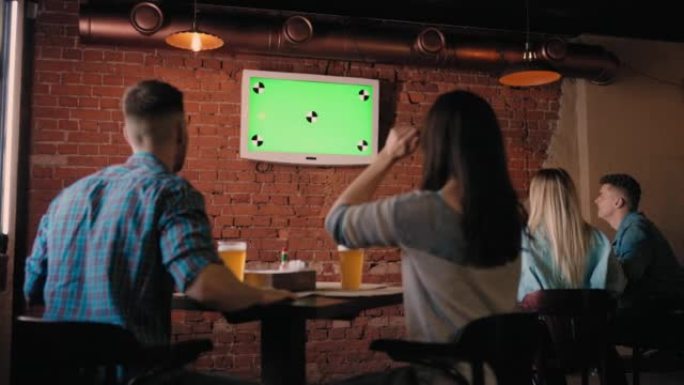 酒吧里一群看着绿色电视屏幕的朋友从座位上跳了起来，互相祝贺。看足球，看曲棍球，篮球。球迷观看世界杯比