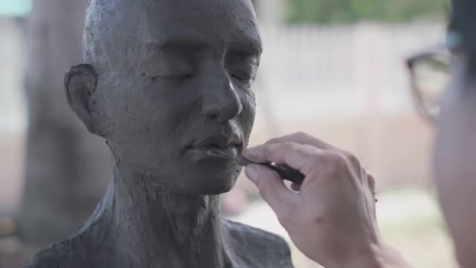 亚洲男子雕塑家创作泥塑。