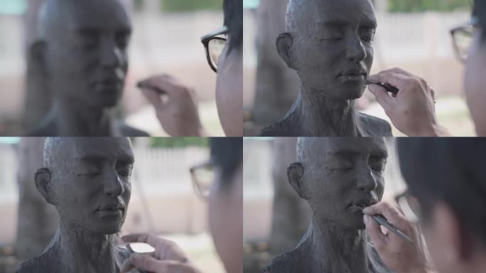 亚洲男子雕塑家创作泥塑。