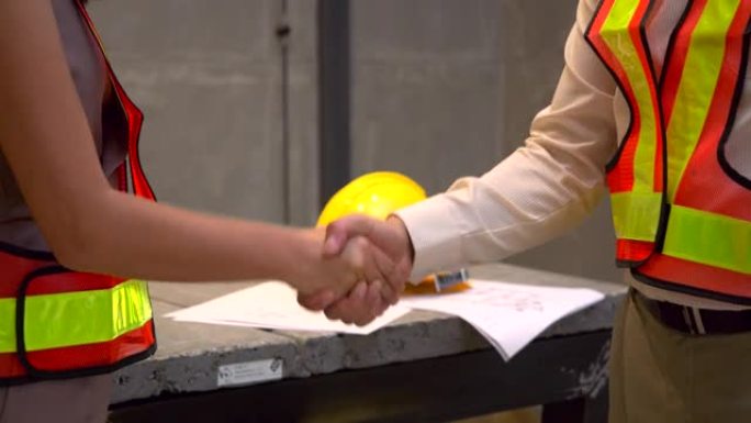 握手，在施工现场工作成功的专业工程师检查工作。