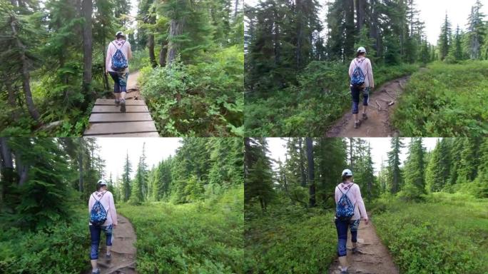 在树林里穿着粉红色徒步旅行的女人的镜头之后