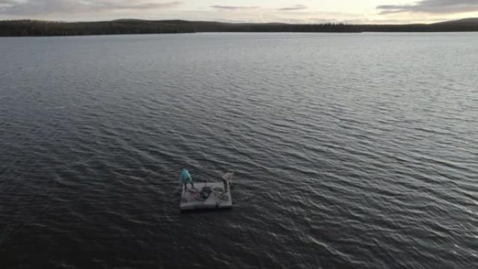空中无人机拍摄了一男一女在湖上的浮动码头上划桨的镜头