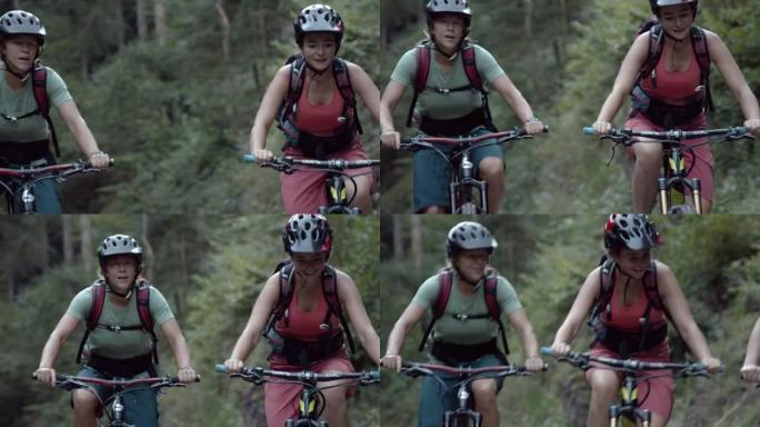 三名女山地车手一起骑在树林中的铺砌道路上