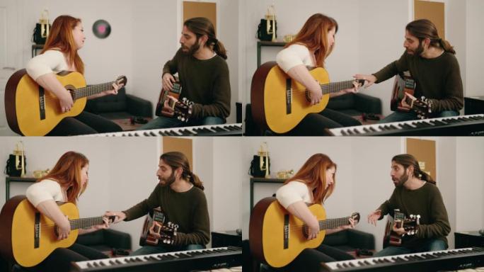 Man and woman having guitar lesson at music studio
