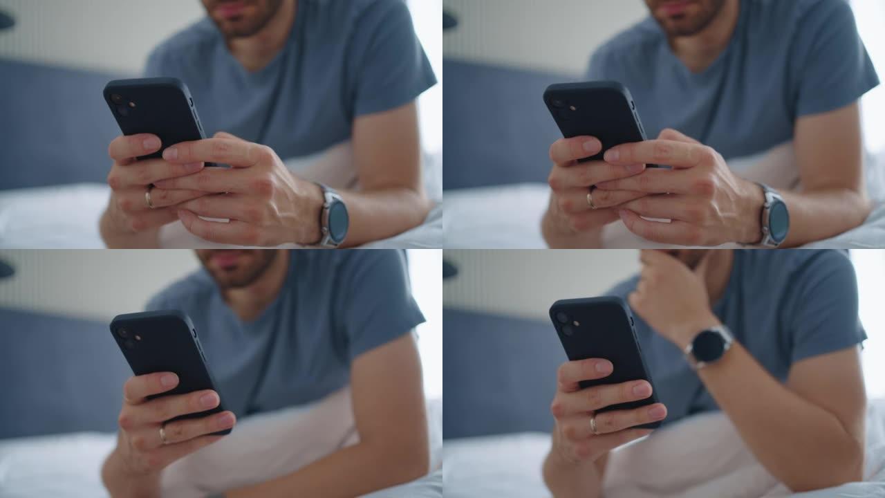 年轻人清晨坐在床上使用智能手机。一个年轻人坐在床上，用智能手机发送信息的真实特写镜头
