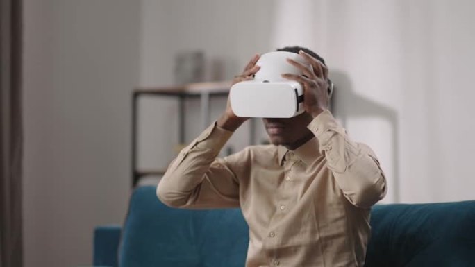 年轻的黑人正在关闭头戴式显示器，用现代小工具观看虚拟现实的中等肖像