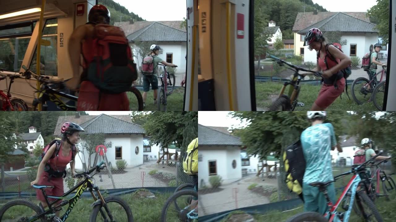 三名年轻妇女在车站将山地自行车从火车上走下来