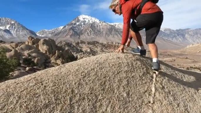 男性徒步旅行者登上沙漠岩石
