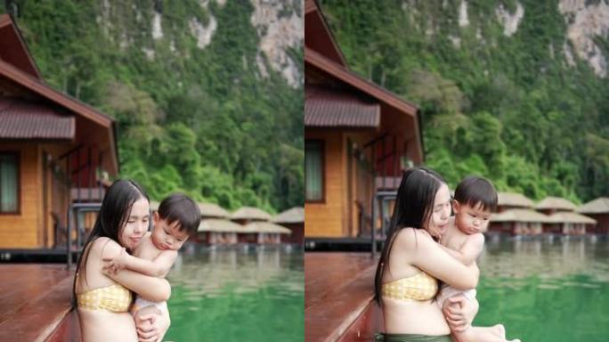 亚洲母亲抱着并亲吻她的男婴
