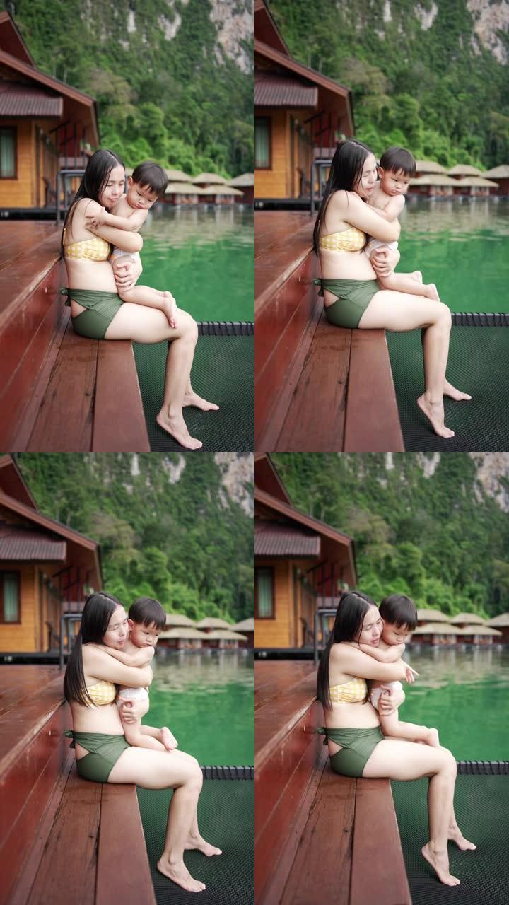 亚洲母亲抱着并亲吻她的男婴