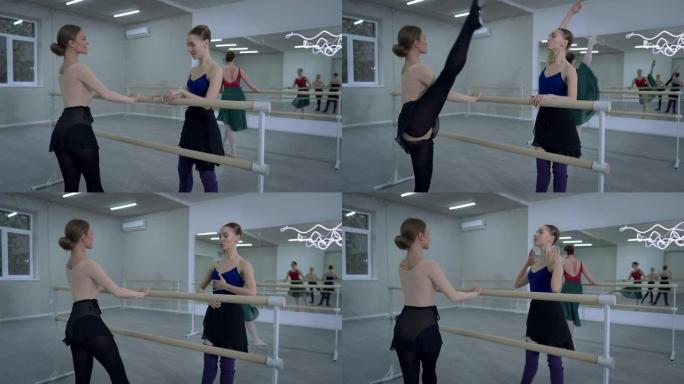 自信的职业芭蕾舞演员说话帮助朋友排练举起腿抱着巴雷。积极自信的白人女性在工作室室内跳交际舞。优雅和艺