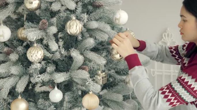女人的手在房子里的客厅里装饰圣诞树。