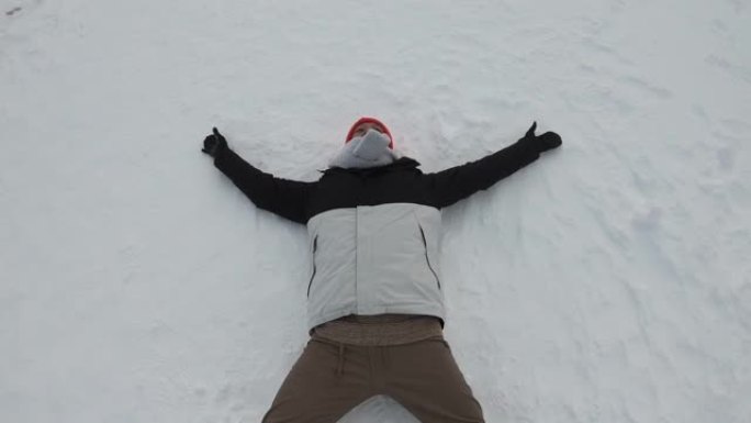 人躺在雪中，在晴朗的冬天，在蓬松的雪中做一个天使。一个躺在雪地里做天使的女人从上到下开枪。