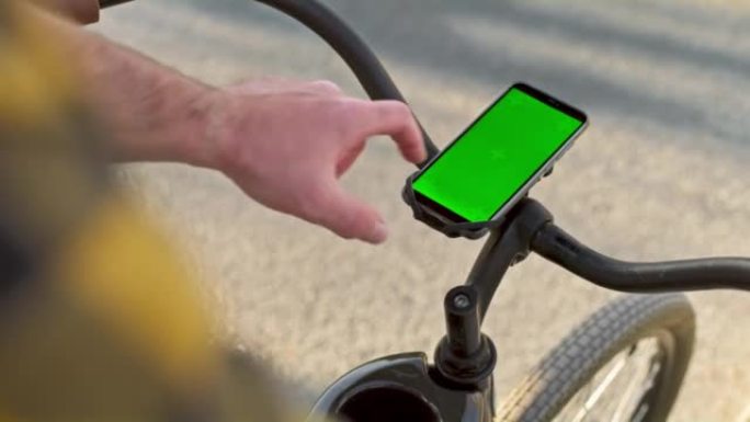 男子按下城市自行车车把上智能手机的屏幕
