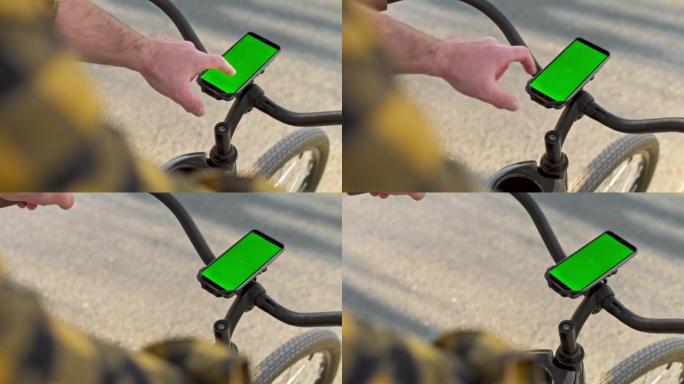男子按下城市自行车车把上智能手机的屏幕