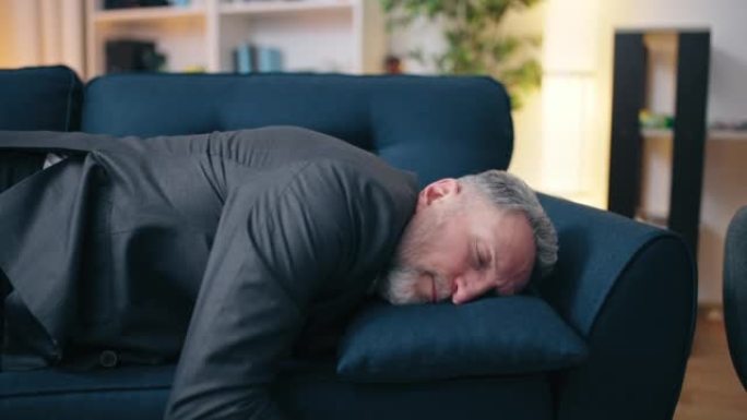 50多岁的男子在辛勤工作，过度劳累，疲惫后在沙发上入睡