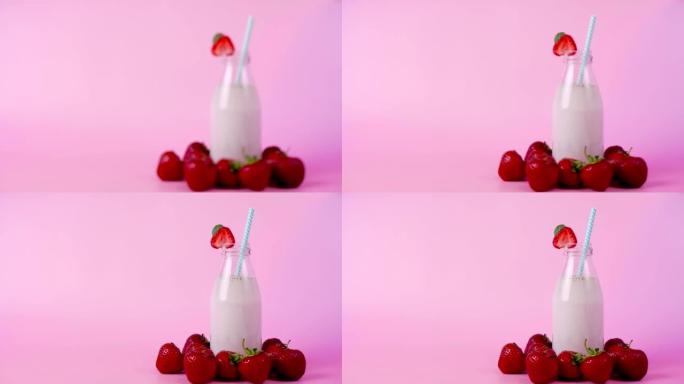 焦点不在瓶子里的草莓冰沙或奶昔慢慢聚焦在粉红色背景上
