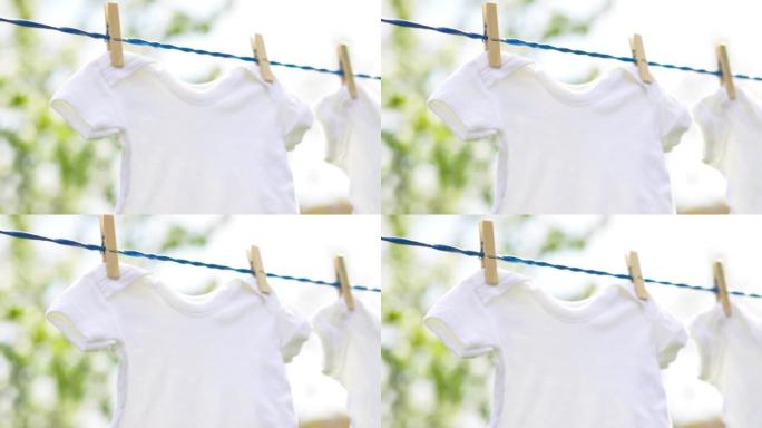 春季户外挂在绳子上的白色婴儿衣服