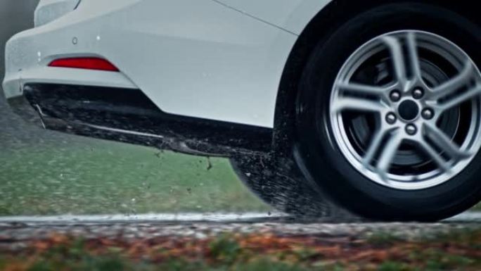 一辆白色汽车的后轮胎在雨中经过