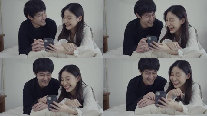 幸福的年轻夫妇在家里看手机