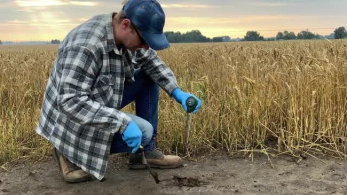 农民使用土壤测试仪测量土壤pH值、湿度、温度