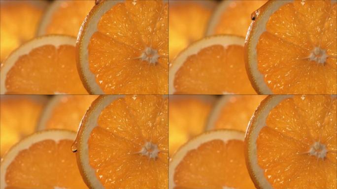 一滴橙色水从成熟多汁的橙色切片的表面流下。慢动作4K