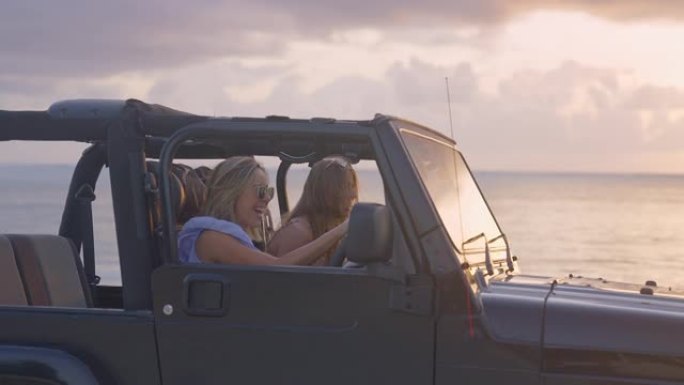 女性朋友们逃到田园诗般的海滩。透过SUV车窗看。田园诗般的日落