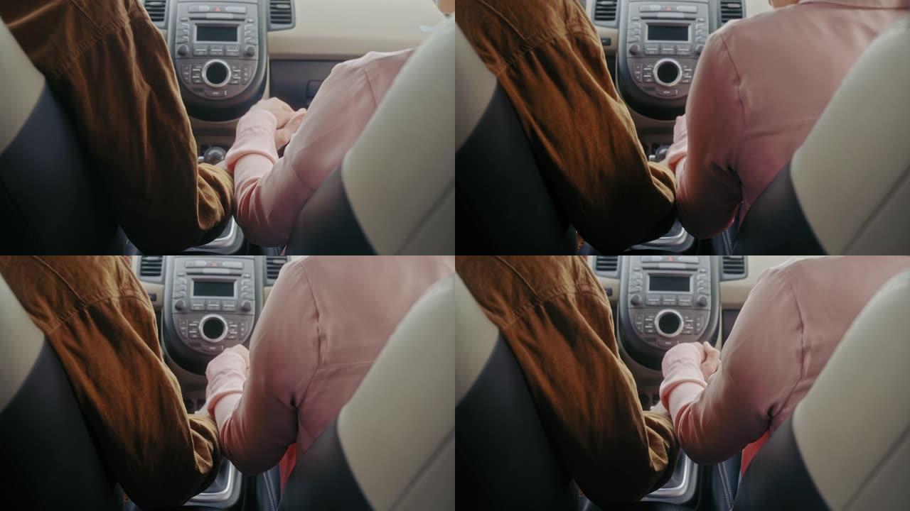男女手牵着手，一起坐在车里，浪漫的手势