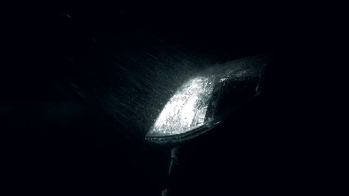 汽车前大灯光线中有雨滴和细水悬挂