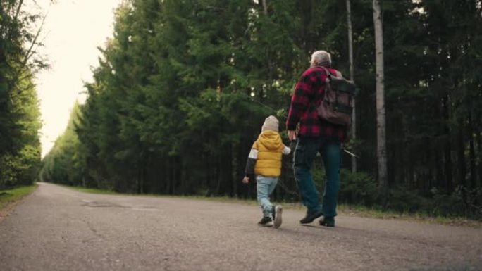 老渔夫和他的小孙子早上在穿越森林的路上行走，爷爷背着棍子