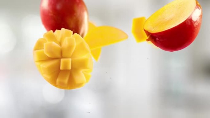 厨房背景中的芒果和切片的飞行