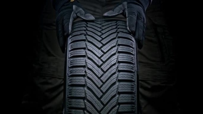 SLO MO LD戴着手套旋转全新的汽车轮胎