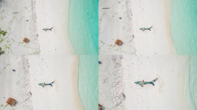 空中无人机在形状像鲨鱼的海滩上拍摄渔网