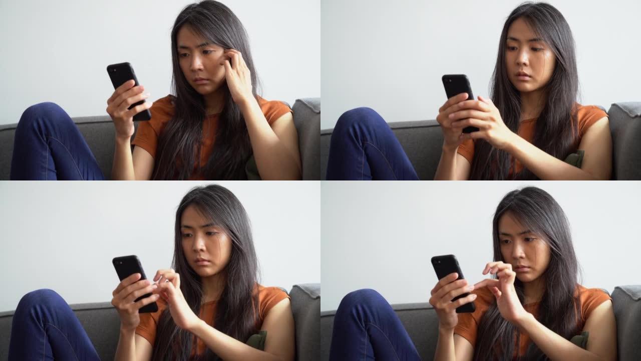 亚裔美国妇女在手机上做个人理财的中景肖像
