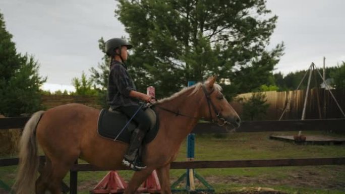 小马俱乐部的马术课，小女孩在围场骑马，在牧场慢慢走