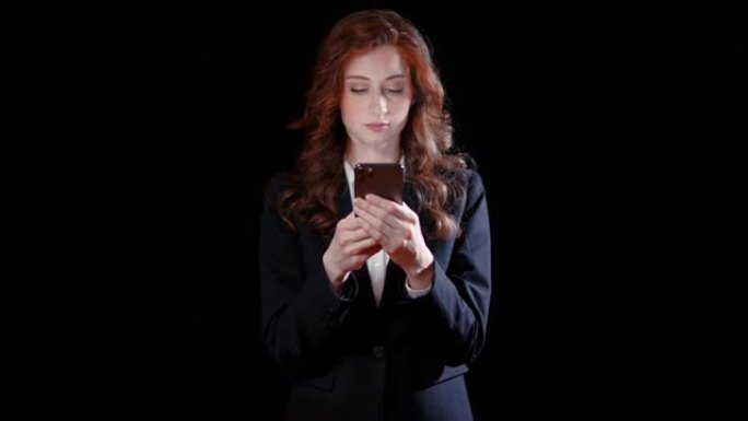 白人女商人在手机中性表情上发短信-黑色背景