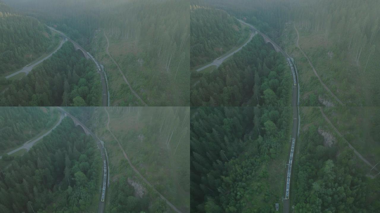 空中无人机拍摄的火车在黄昏时穿越森林