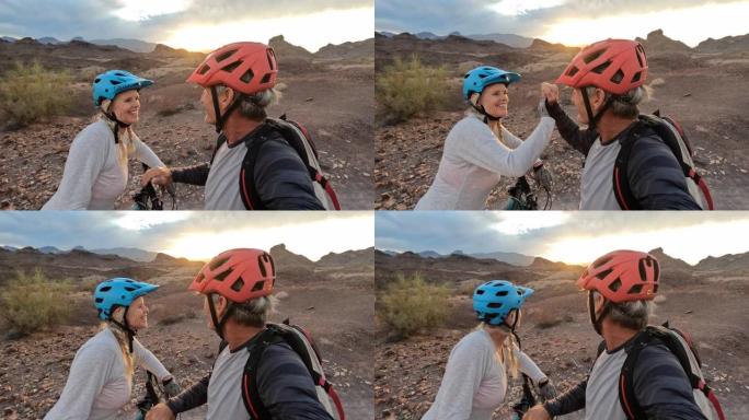 山地自行车夫妇在沙漠上享受最后的阳光