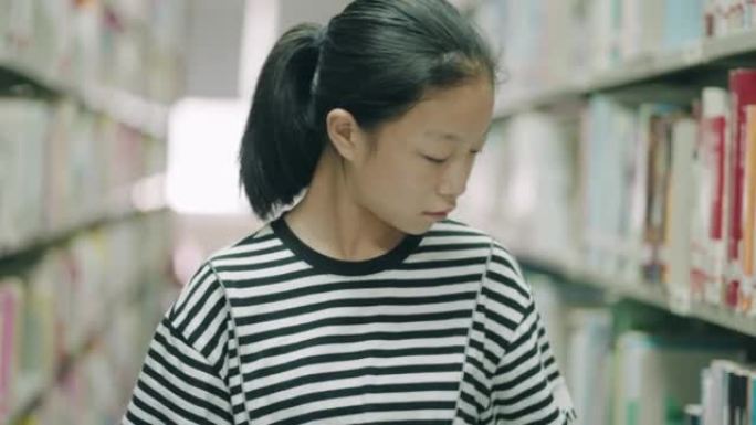 这个女孩正在图书馆里找书