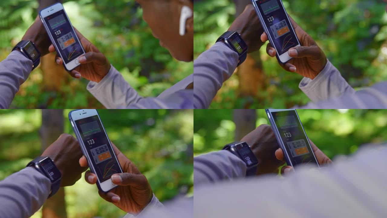 SLO MO多民族女跑步者在森林中检查手机和智能手表上的数据