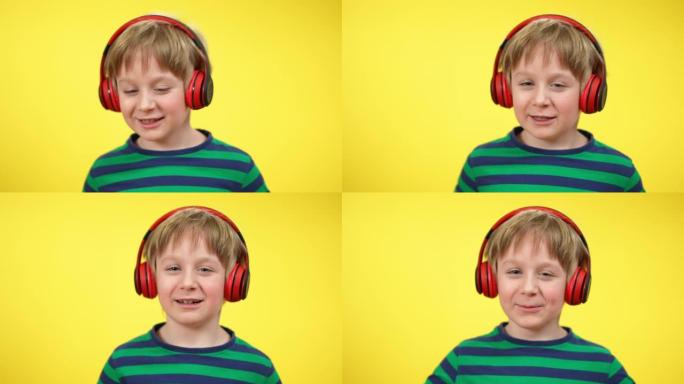 欢快迷人的高加索男孩在黄色背景下戴着耳机唱歌跳舞的特写镜头。积极快乐的孩子享受耳机播放列表音乐。爱好
