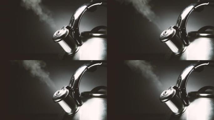 沸腾的钢制银水壶，带有黑色背景上的蒸汽特写哨子。4k原始慢动作视频60 fps。