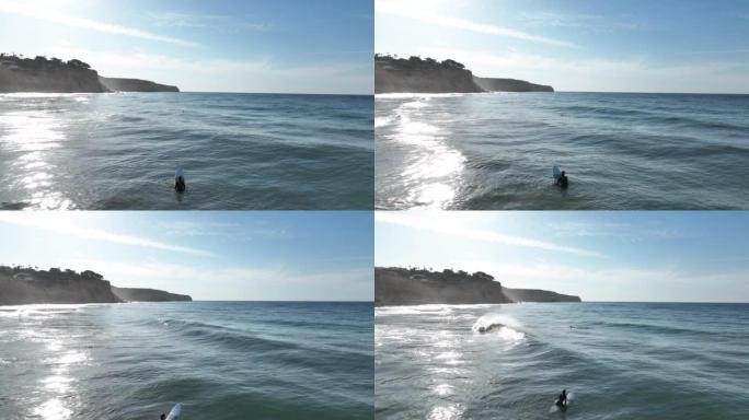 沿海岬角的鸟瞰图，年轻女子前往冲浪