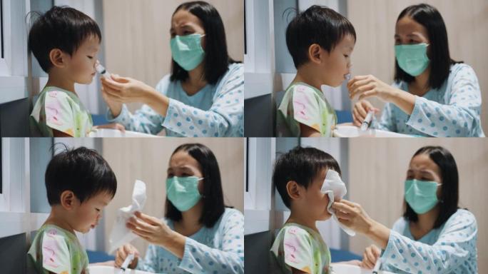 妈妈帮她的小男孩用盐水做鼻腔冲洗清洁