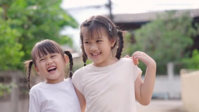 两个年轻的亚洲女孩在自然环境中灿烂地微笑。