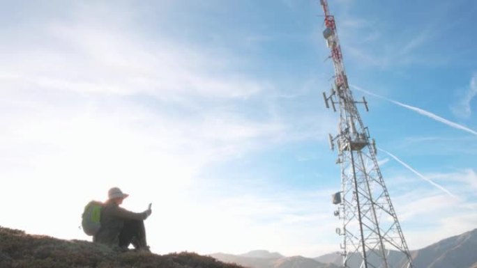 山顶上的电信塔的视图，下面的徒步旅行者