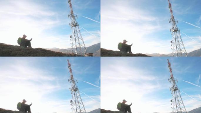 山顶上的电信塔的视图，下面的徒步旅行者