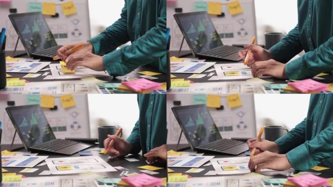ux/ui开发人员的手在办公室的桌子上设计移动应用程序的特写